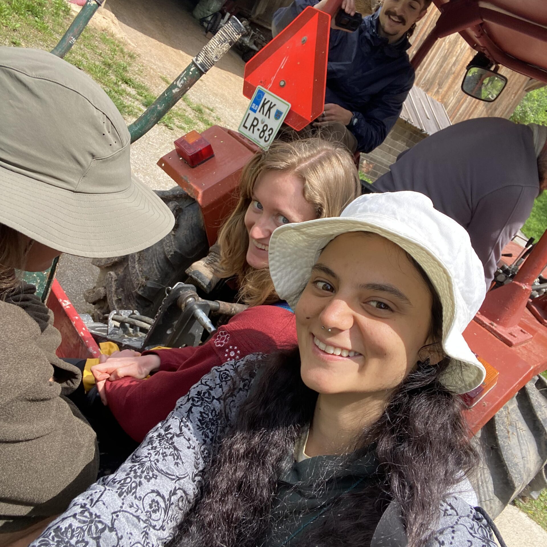 Volunteers riding the tractor with Janez